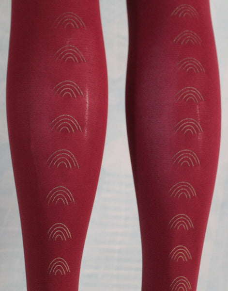 80 Denier burgundy tights, hand screen printed rainbows in gold, close up picture of rainbow print