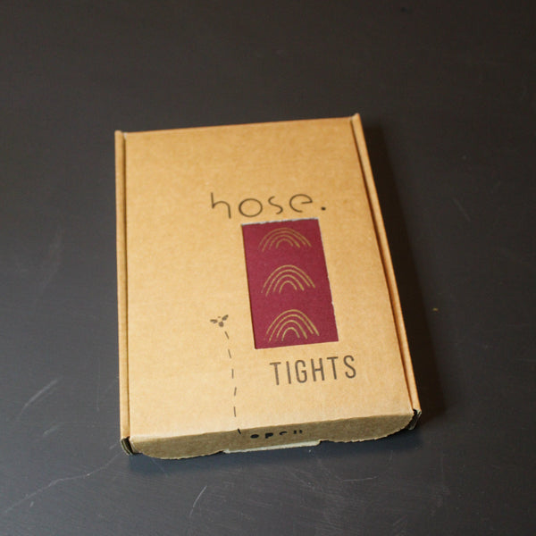 80 Denier burgundy tights, hand screen printed rainbows in gold, packaged in hand screen printed recyclable cardboard box 